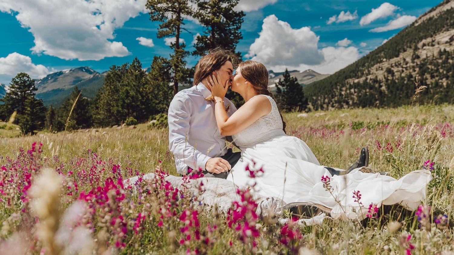 Mountain wedding ceremony site with wildflowers and dramatic blue skies in the background.