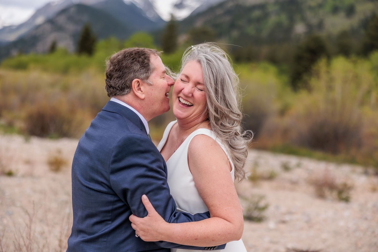 A tender moment between newlyweds captured against majestic mountain scenery.