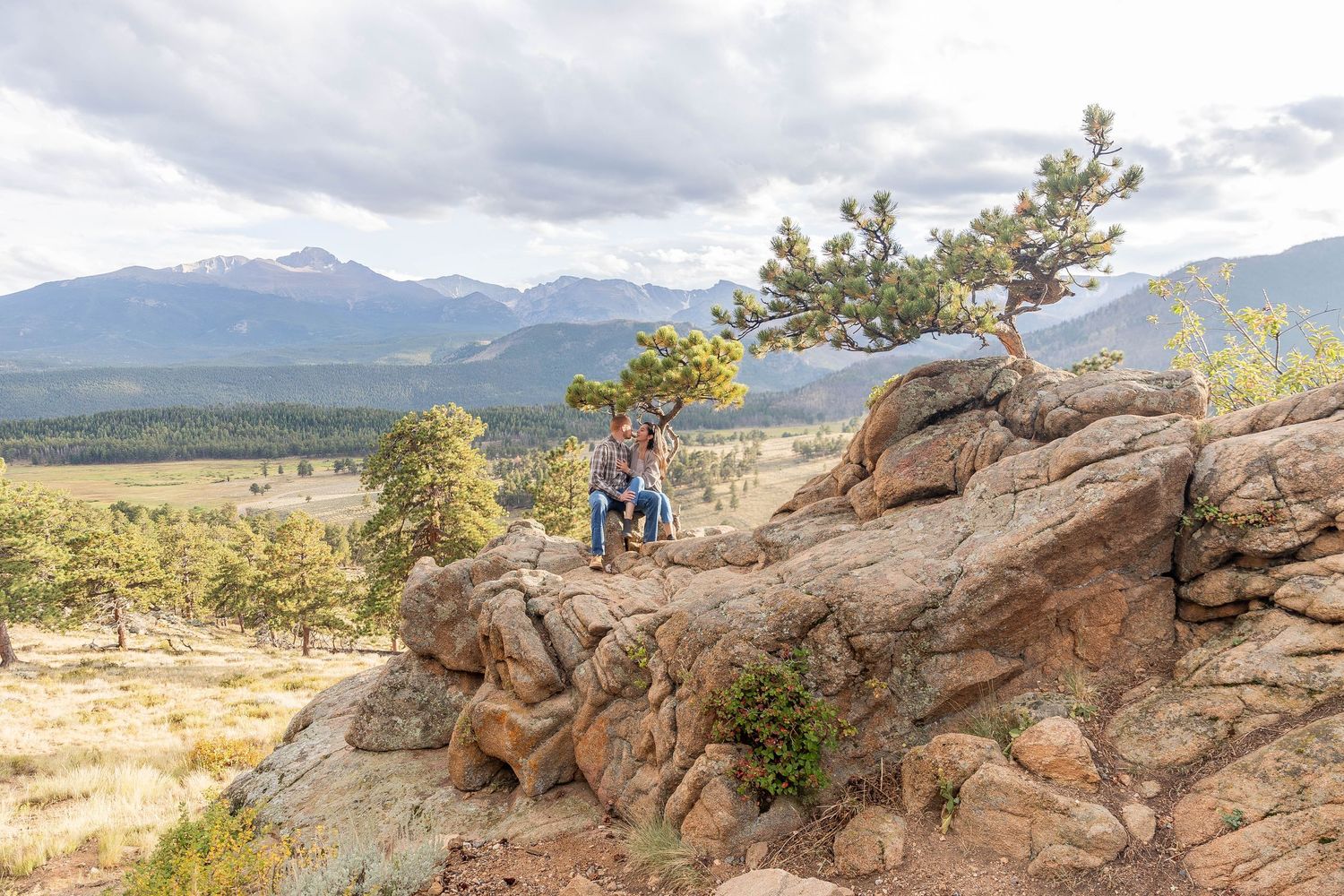 A scenic mountain landscape with rugged rock formations and distant peaks under cloudy skies in Colorado.
