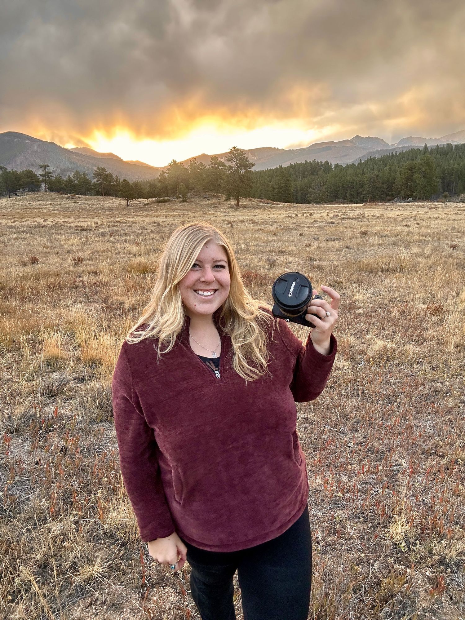 Outdoor photography session at sunset in a mountain field with golden light.