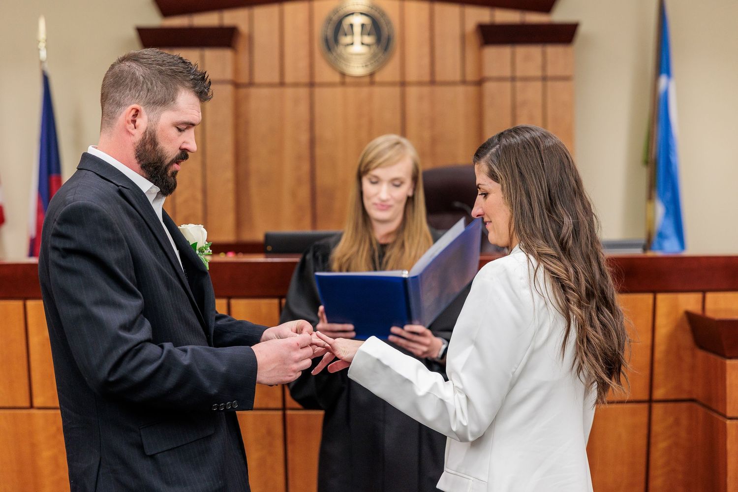 A ceremony taking place in a traditional courtroom setting with wooden paneling.