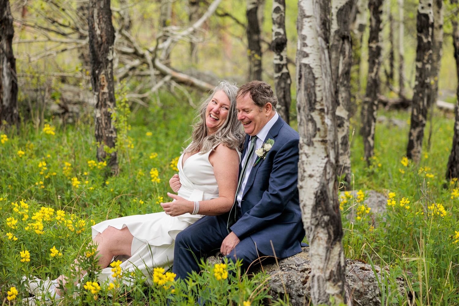 Intimate moment captured in aspen grove surrounded by yellow wildflowers and natural light.