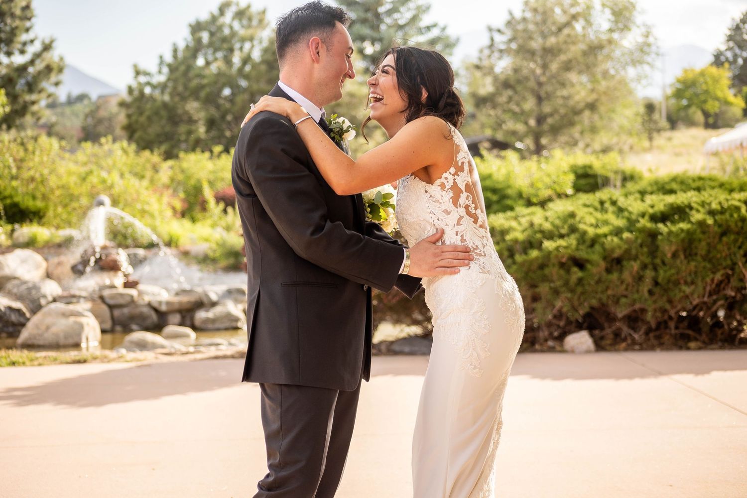 Romantic outdoor wedding portraits captured in golden sunlight among natural landscape.