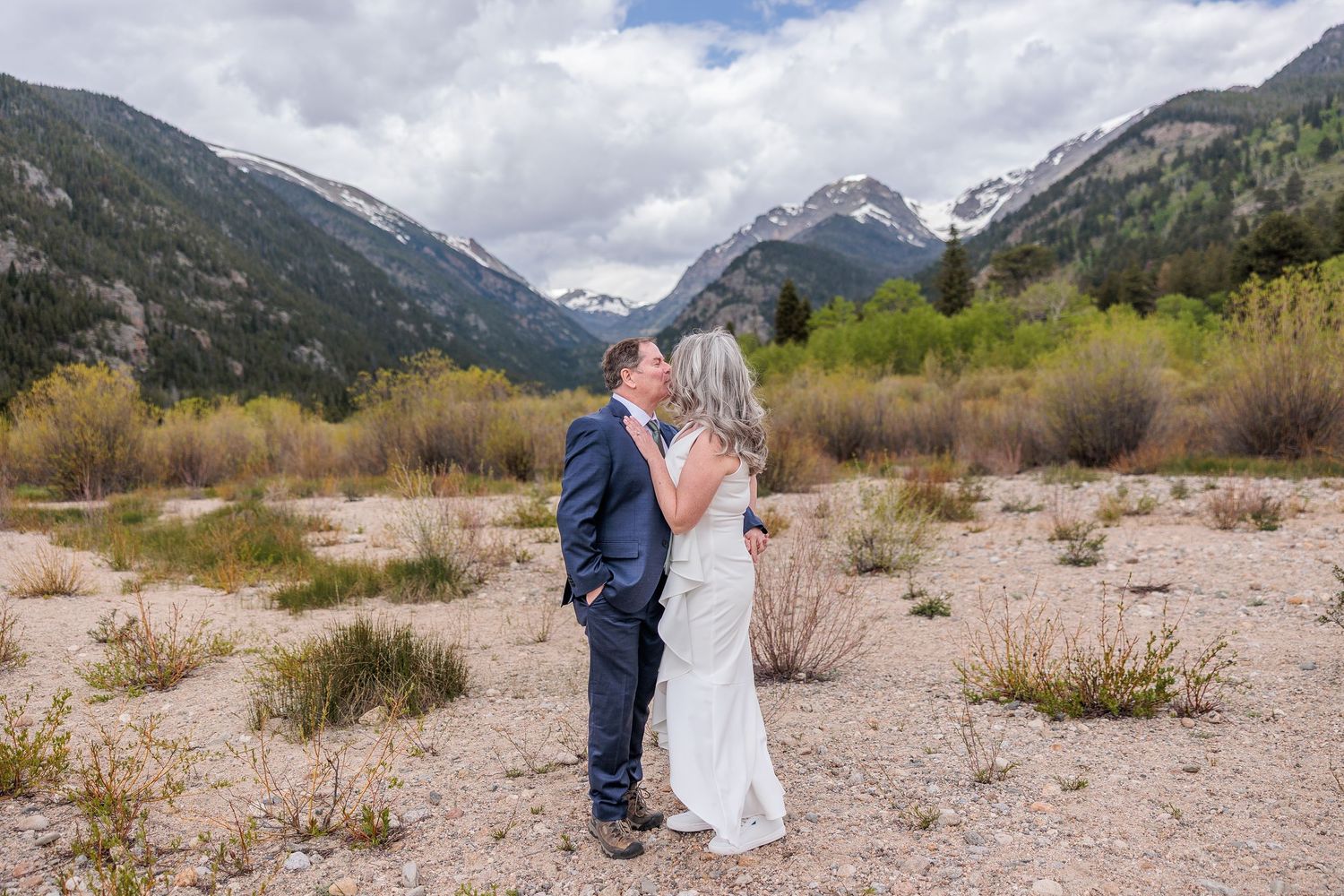 Dramatic mountain peaks and blue skies create stunning backdrop for outdoor photography session.