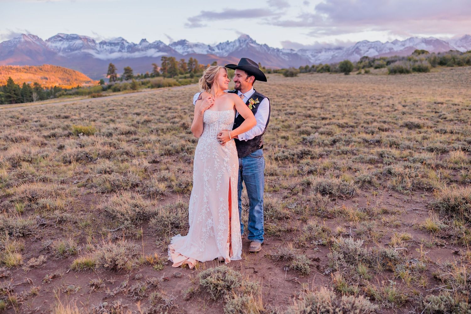 A couple shares a romantic moment during sunset in a scenic mountain field at Top of the Pines in Ridgeway Colorado. Ouray Wedding Photos