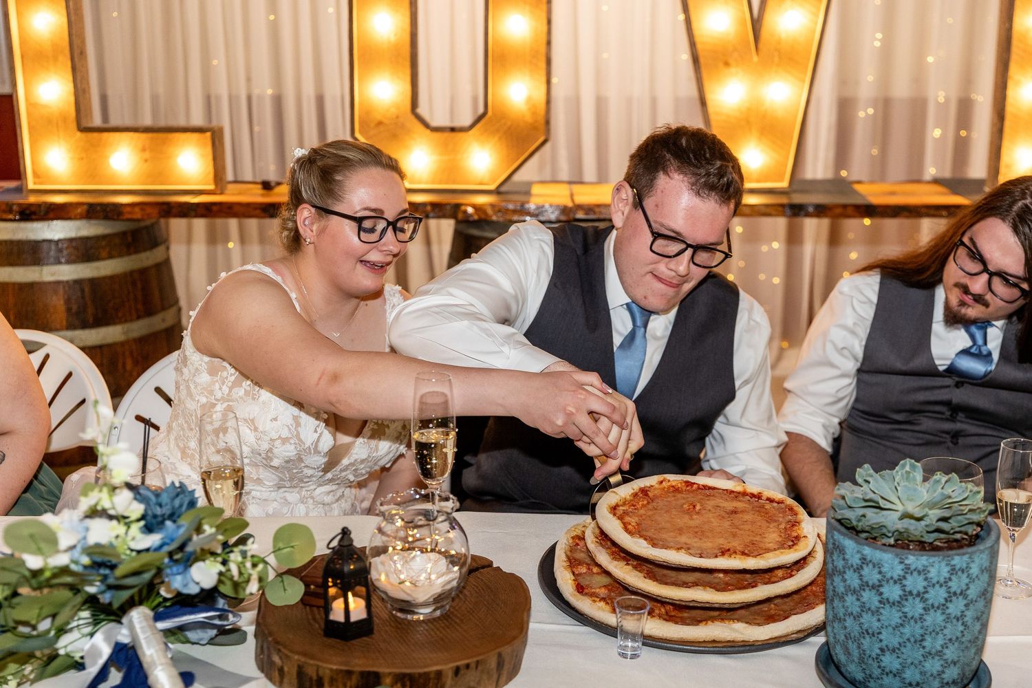 A collage of wedding reception photos showing pancakes, table settings, and guests dining at a rustic venue with glowing lights.