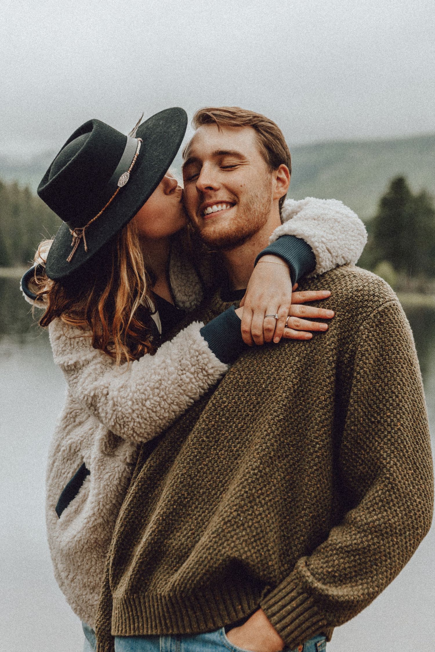 A romantic couple in cozy sweaters sharing intimate moments in a series of outdoor photos on an overcast day.