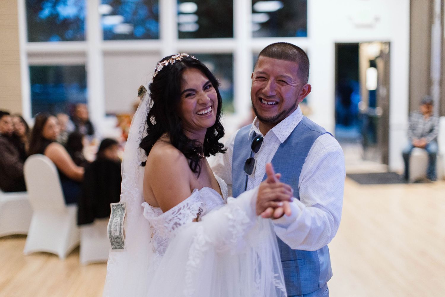 A couple shares a joyful dance together at their wedding reception.