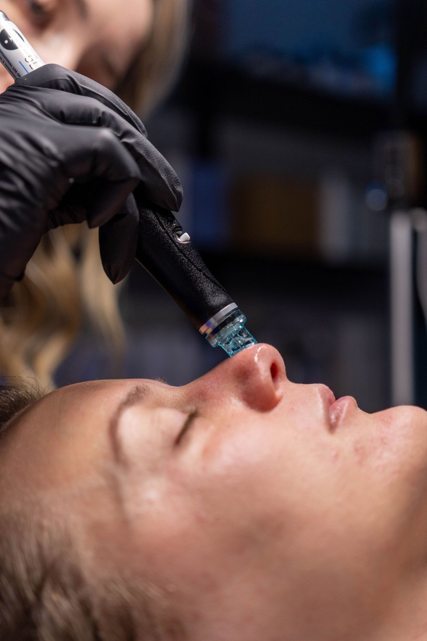 Close-up view of a professional barber giving a precise shave with a straight razor at a barbershop.