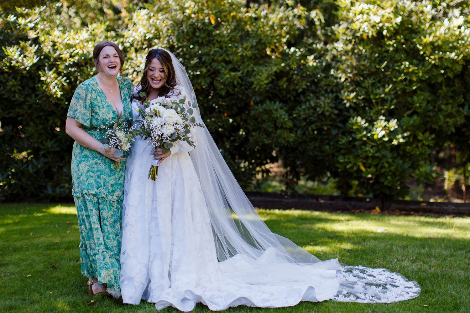 A joyful outdoor wedding scene with people laughing and embracing in a sunlit garden setting.