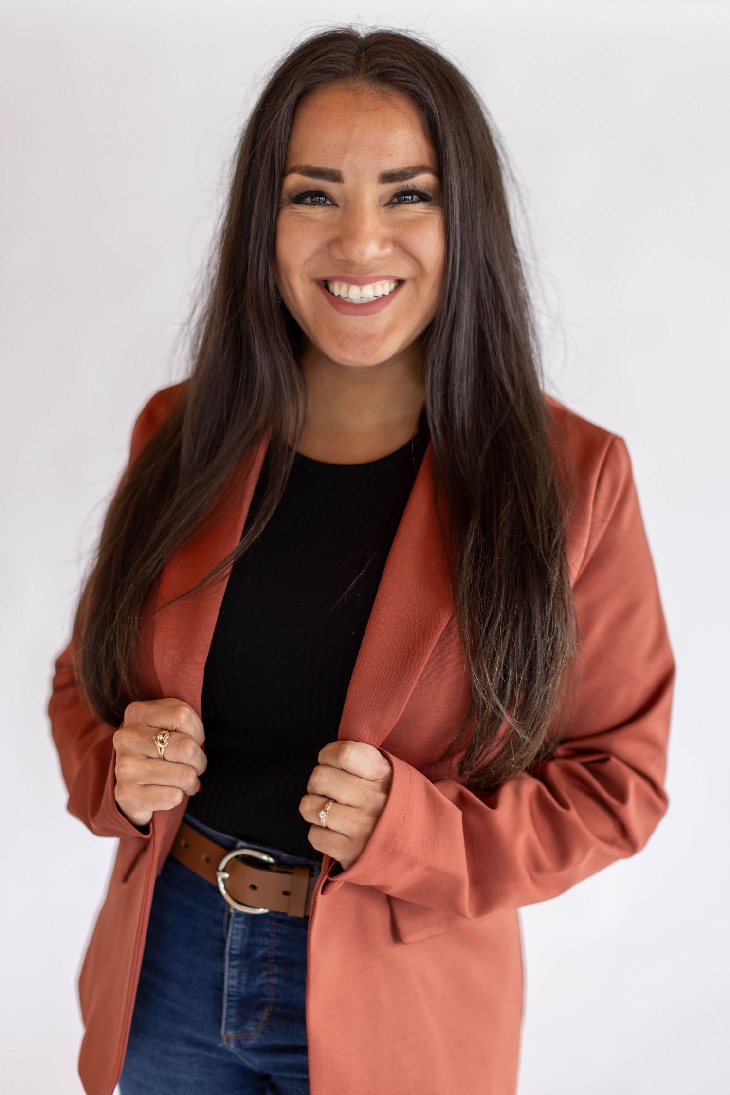 Four sequential photos showing someone wearing a black top and terracotta blazer posing with different expressions against white background.