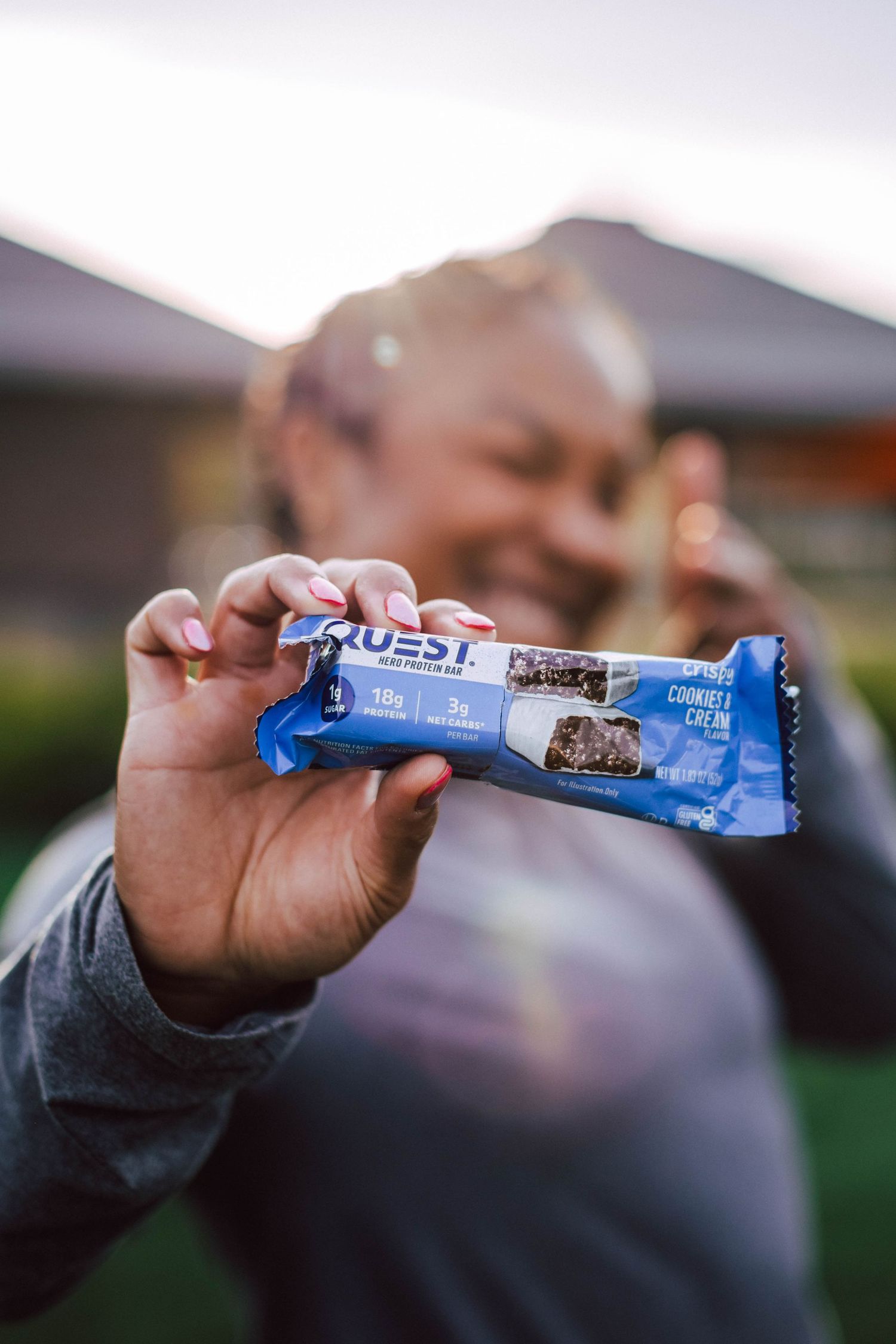 Hands unwrapping a blue Quest protein bar wrapper shown in sequence across multiple photos.