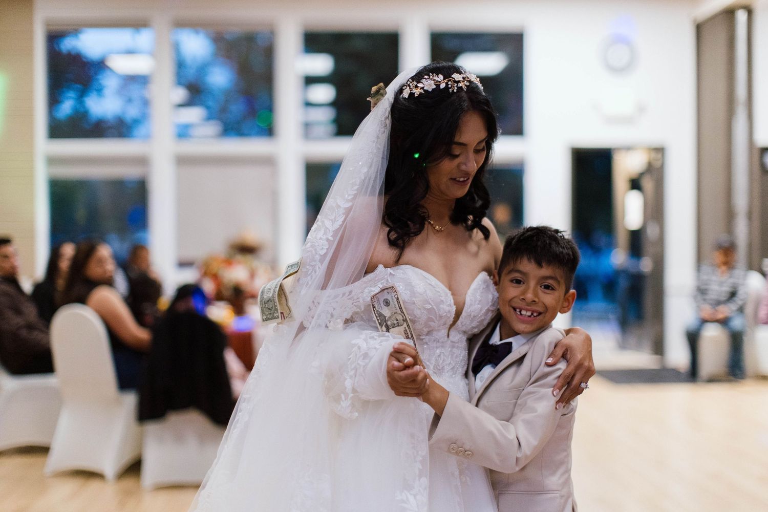 A couple shares a romantic dance together during their wedding reception at an elegant indoor venue.