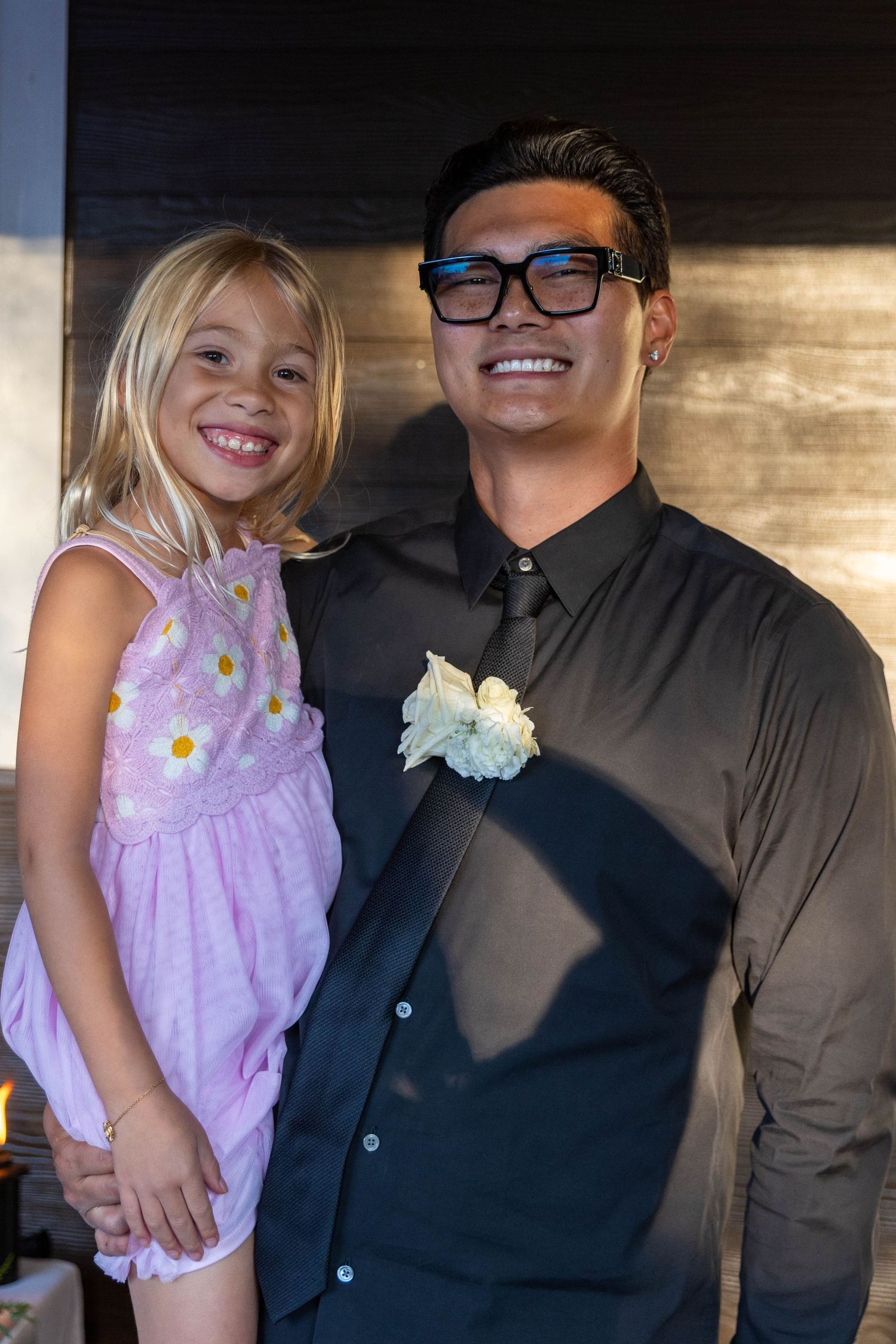 A series of four similar photos showing a young child in a purple dress being held by someone in dark clothing.
