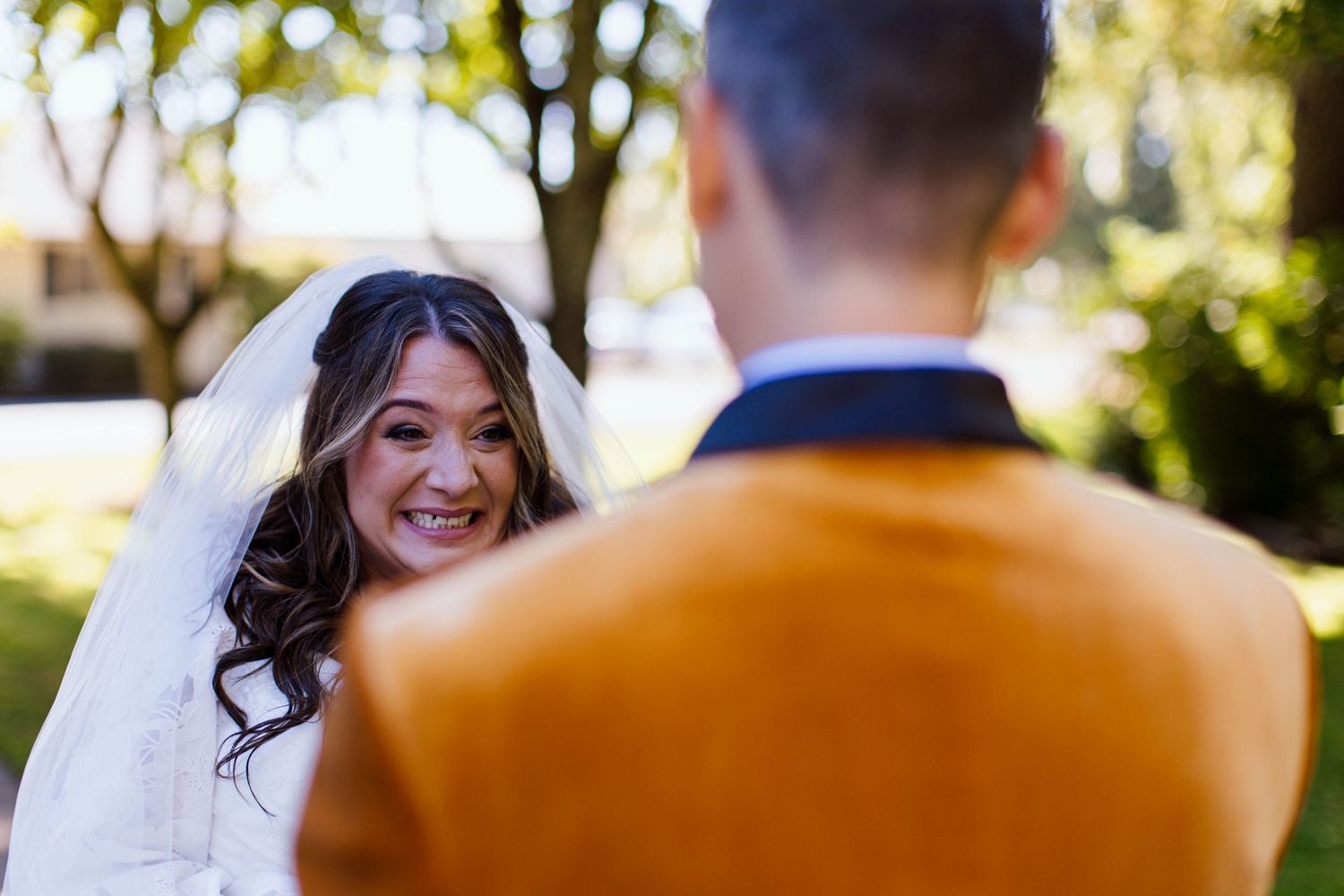Bride and groom share intimate moments in a sunny garden setting during their outdoor wedding photoshoot.