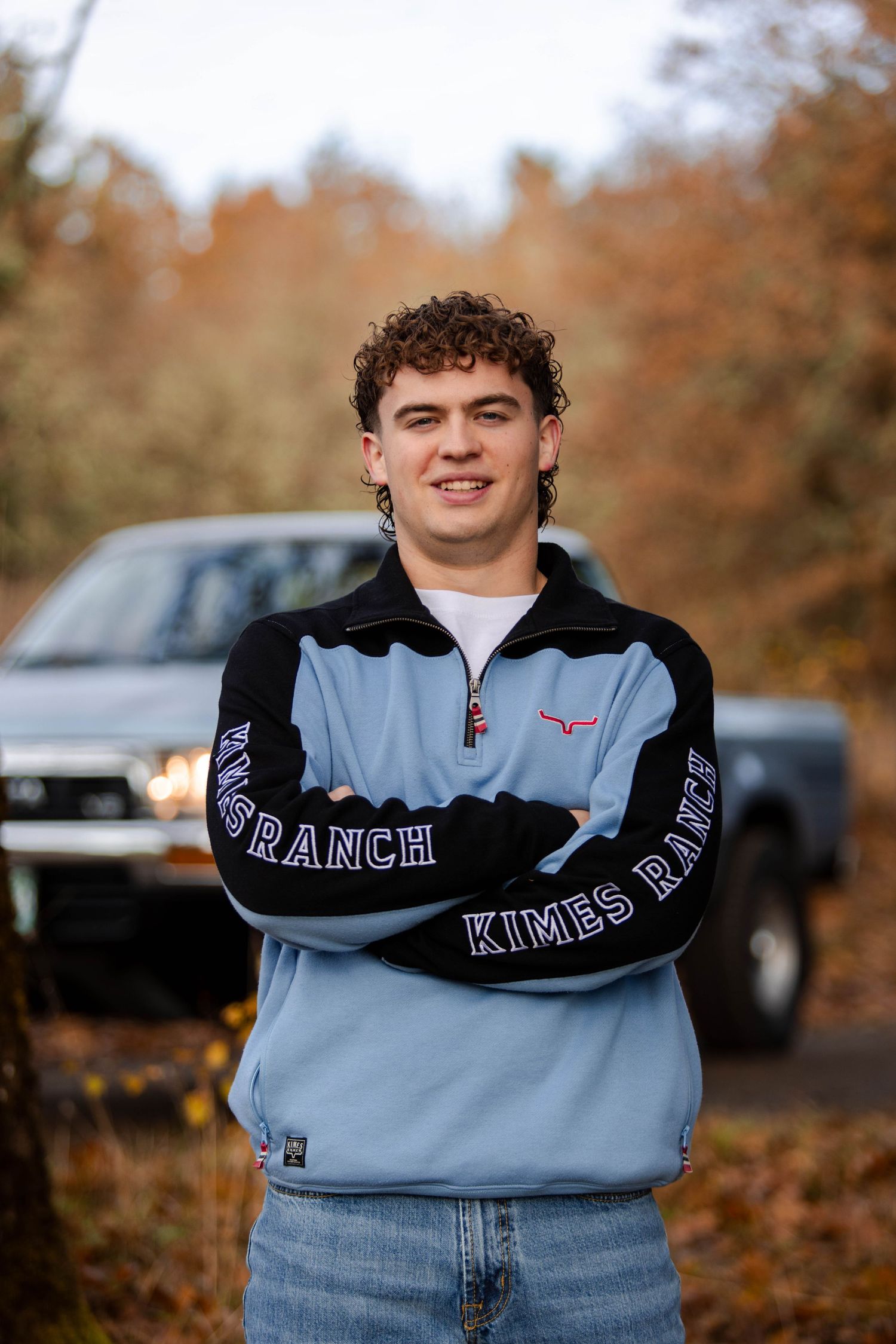 A series of cropped photos showing a light blue sweatshirt with black trim against an autumn background.