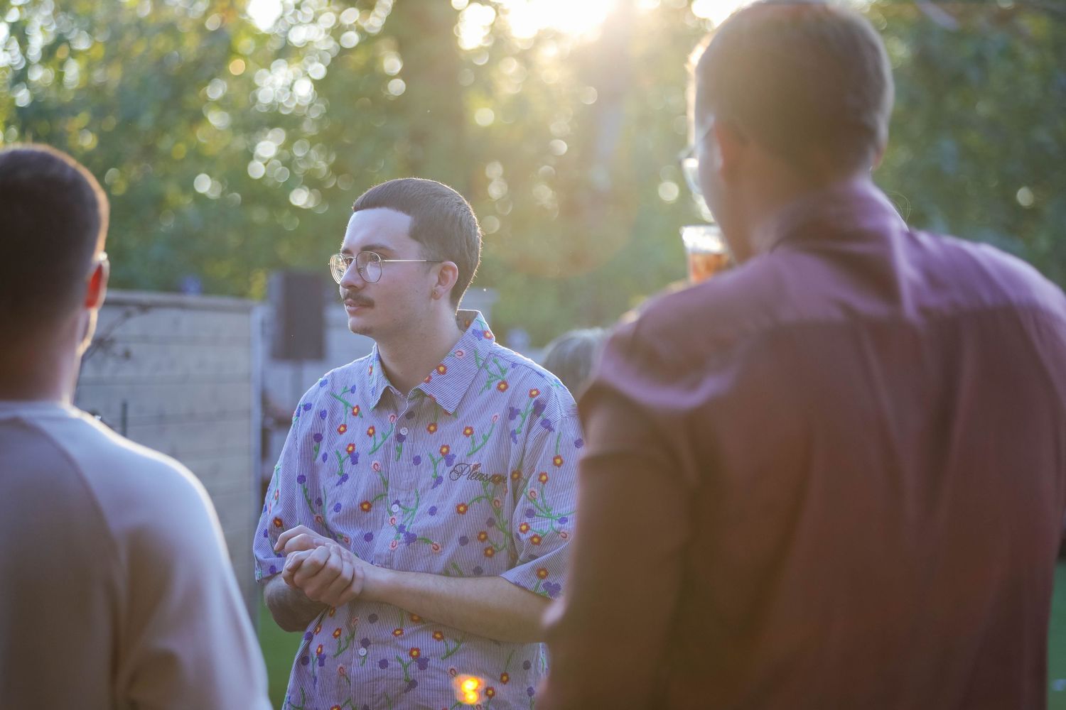 Wedding guests dance together during sunset reception celebrations on outdoor patio.