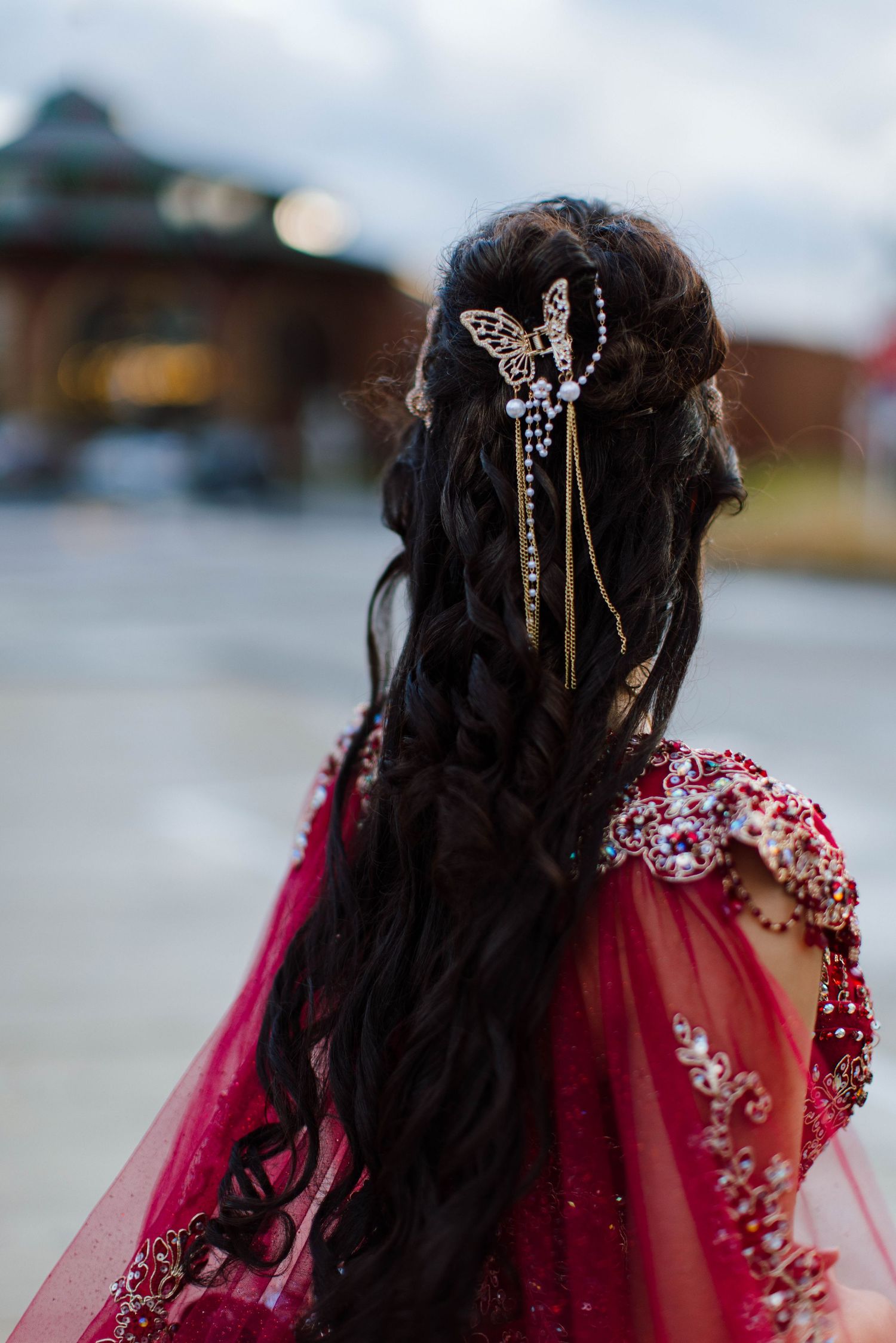 Close-up view of elegant bridal hairstyle with crystal hair accessories and burgundy veil.