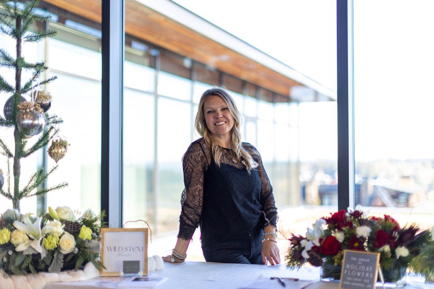 A collection of floral arrangements and decor displayed in a bright, modern retail space with large windows.