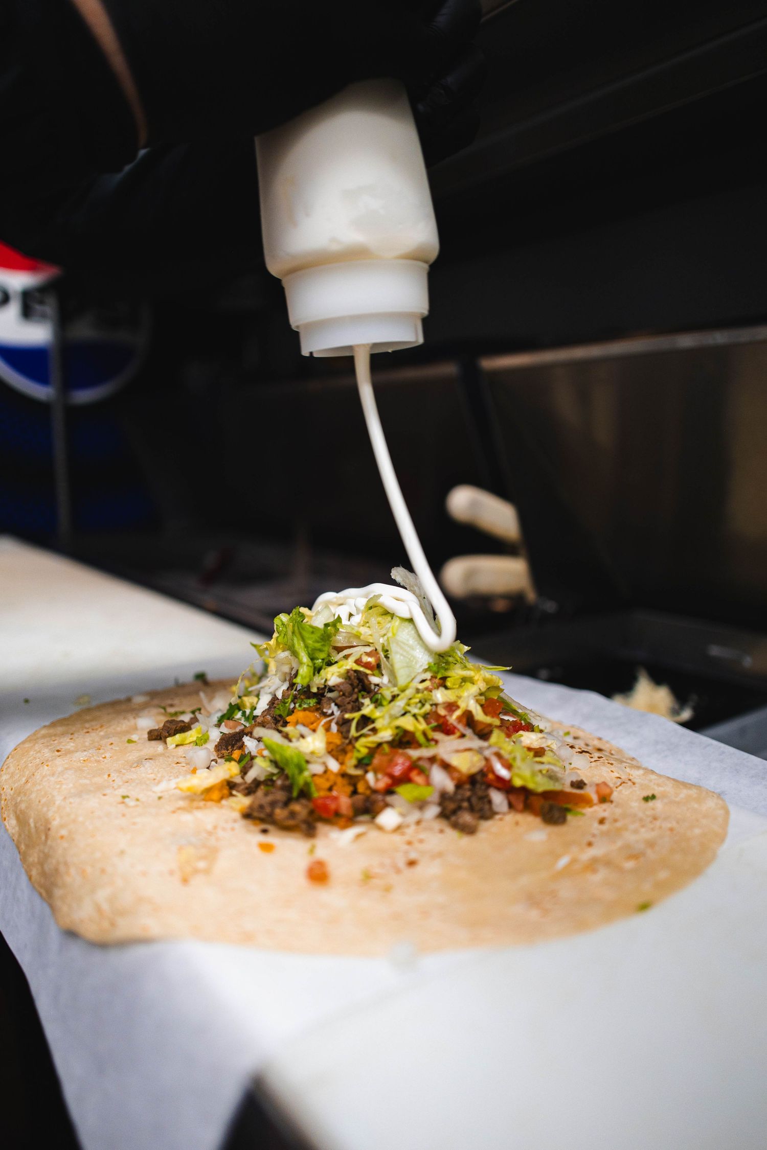 A series of images showing hummus being piped onto plates with various toppings and garnishes being added.