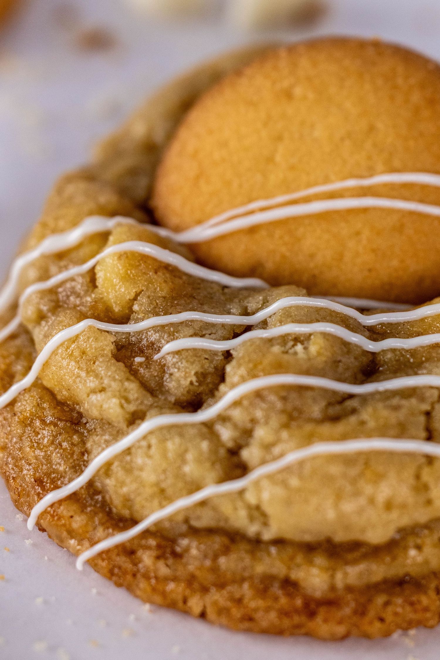 Close-up sequence of a golden brown cookie with white icing drizzle showing different angles and details.
