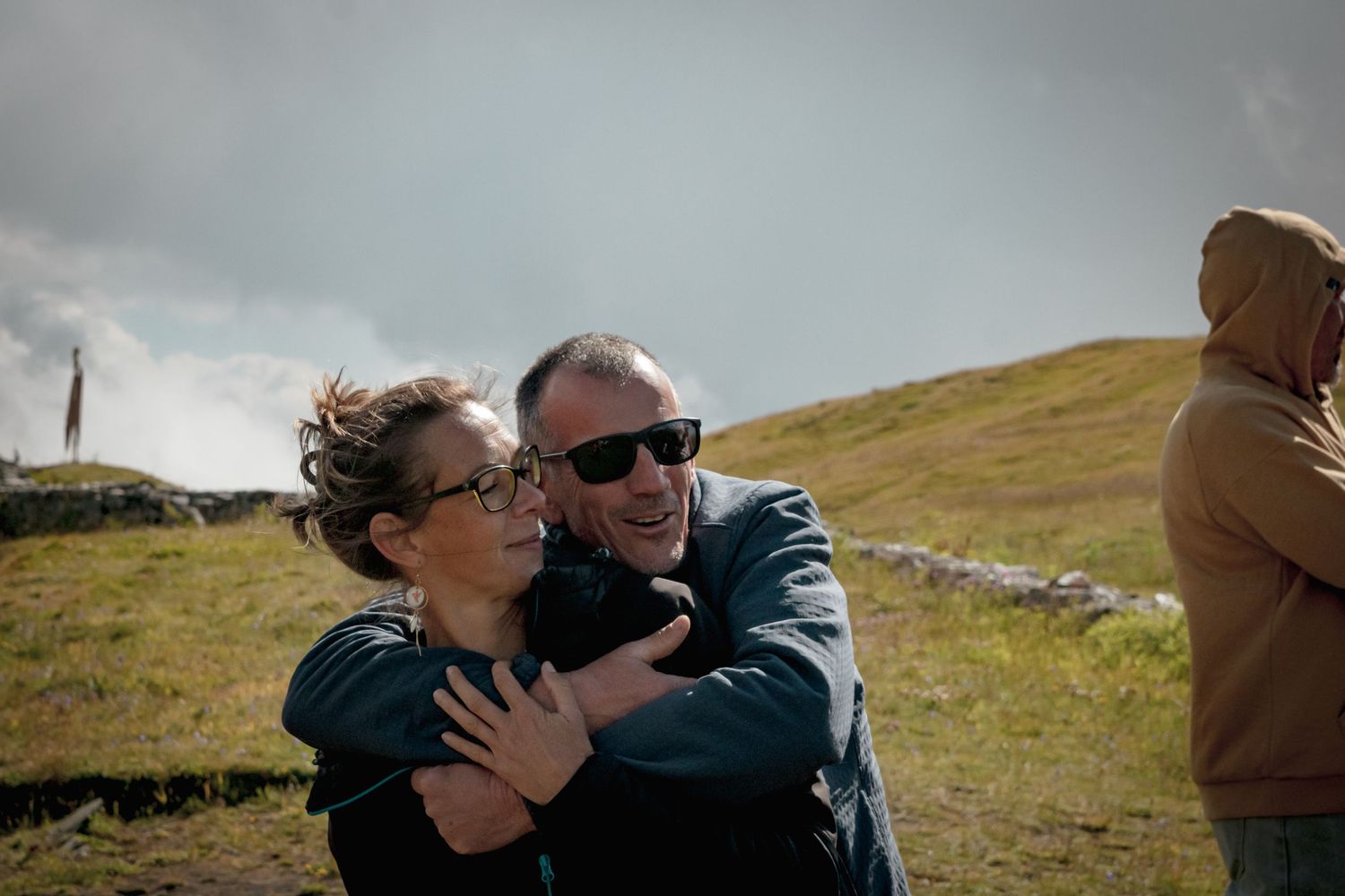 Couple heureux s'étreignant tendrement dans un paysage naturel en extérieur, ambiance joyeuse et spontanée pour une séance photo de couple