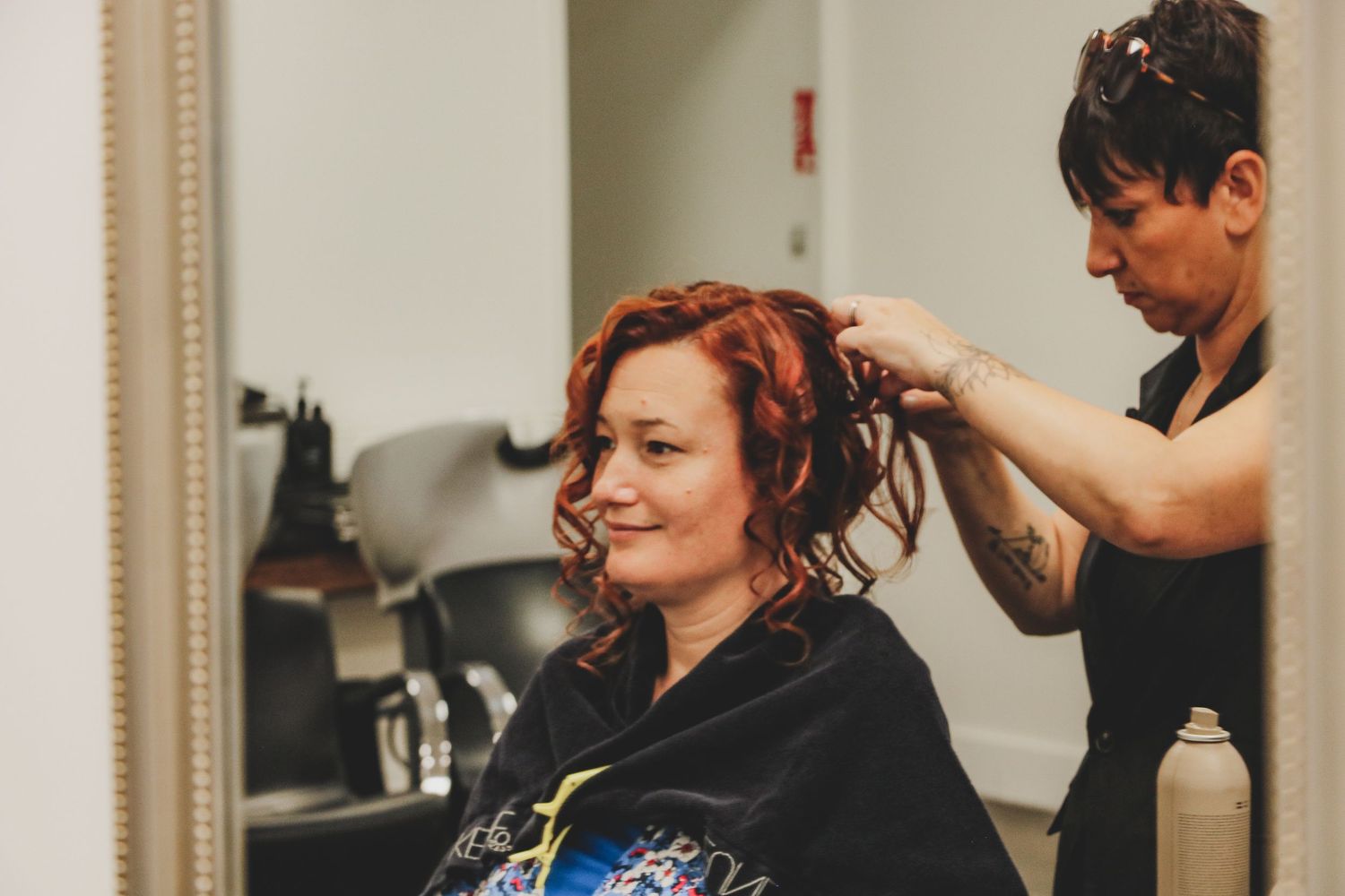 Mariée souriante en préparation coiffure pour son mariage, ambiance détendue et professionnelle en salon