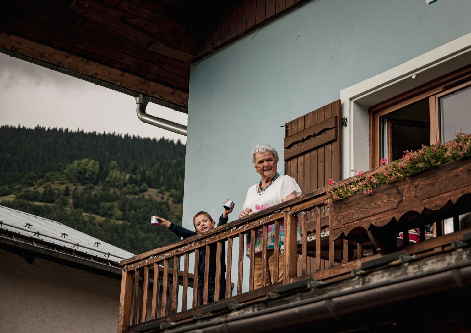 Photo reportage de mariage avec la mamie et son petit-fils sur le balcon de l'hotel restaurant le relais du Villard, en Savoie.