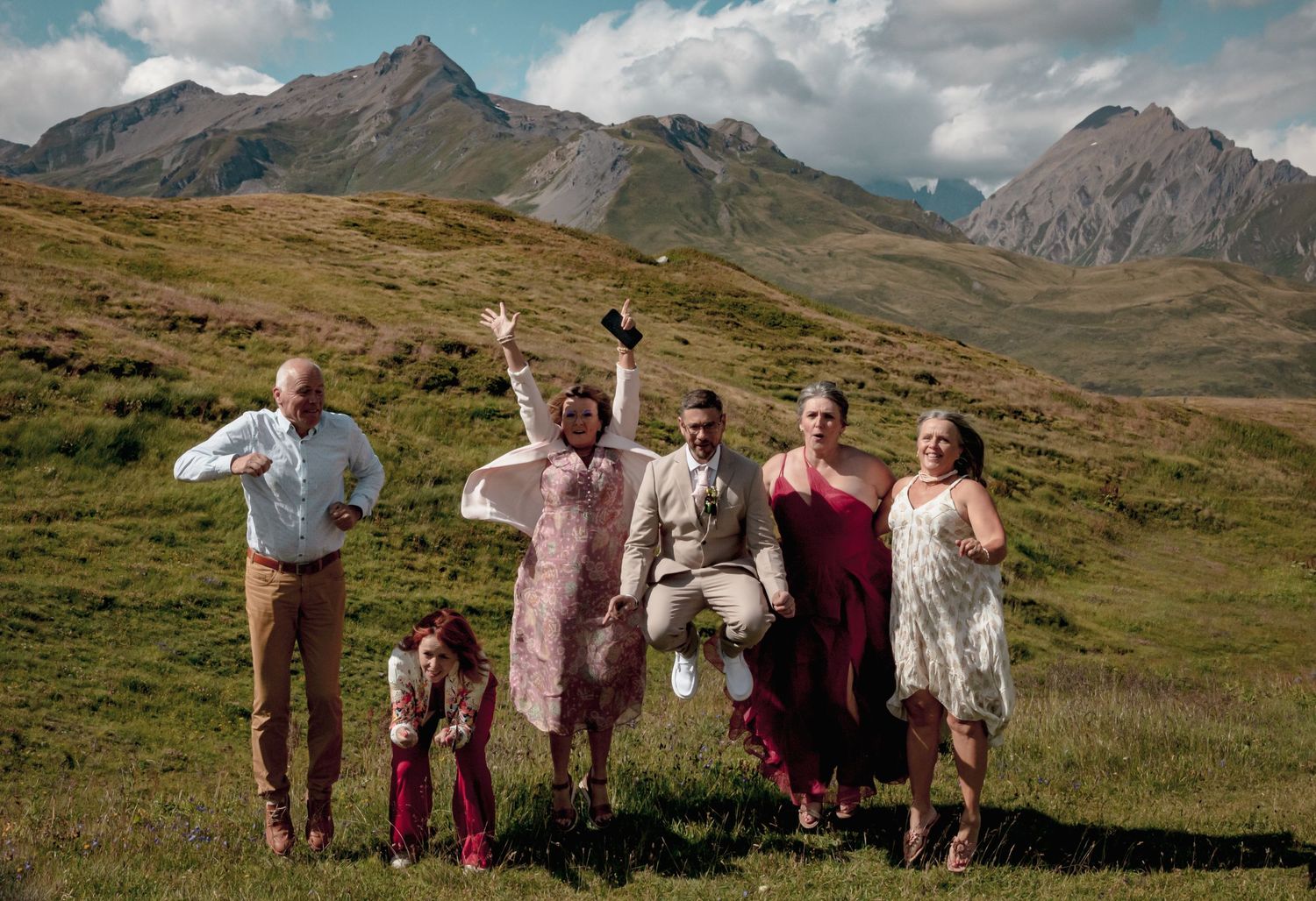 Famille joyeuse en montagne Savoie -  photo mariag lifestyle Alicia Casanova, tenues colorées et paysages alpins pour souvenirs authentiques