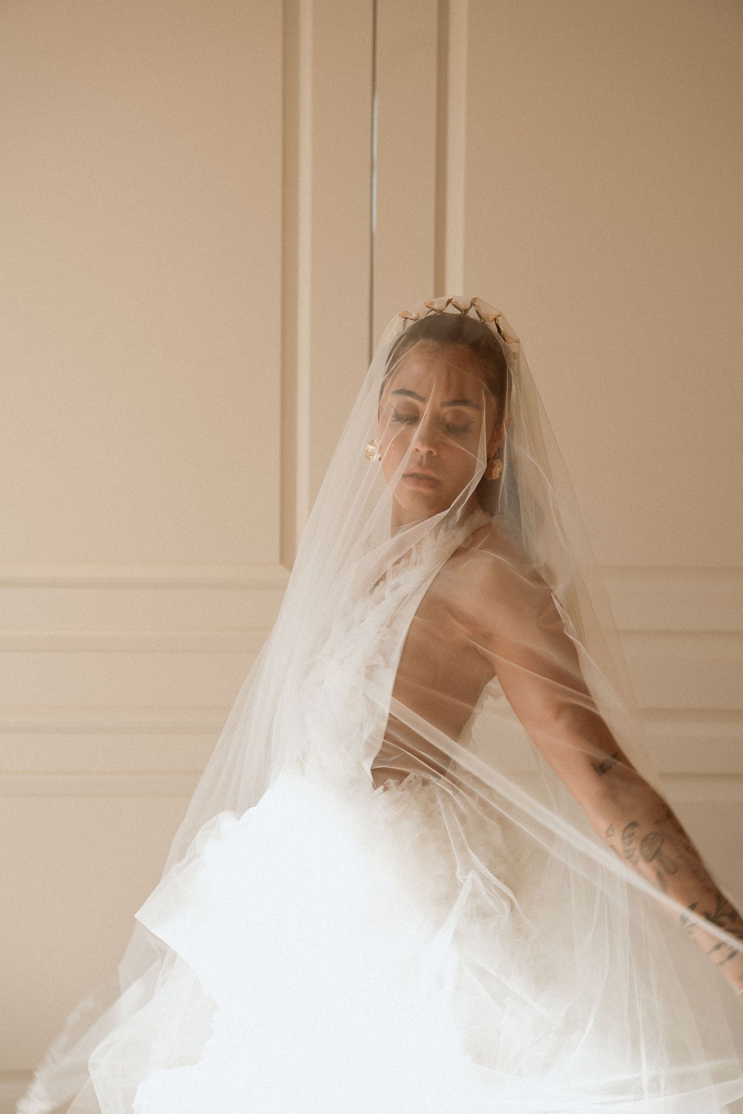 Bride captured in a soft, intimate moment indoors before her wedding ceremony.