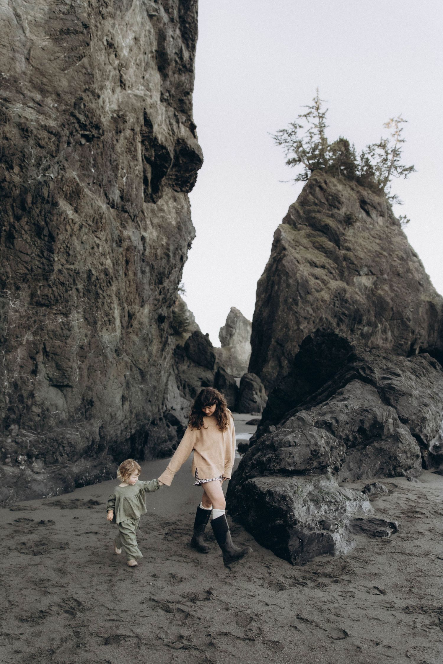 A mom peacefully exploring the beach with her little girl during a sunrise documentary photoshoot