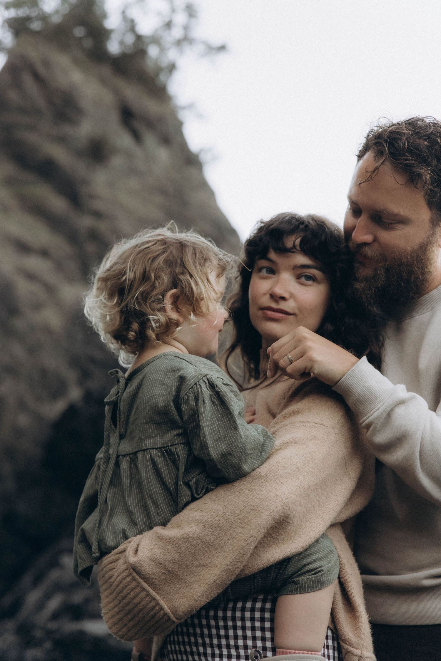 A dad looks lovingly at his daughter while mom holds her