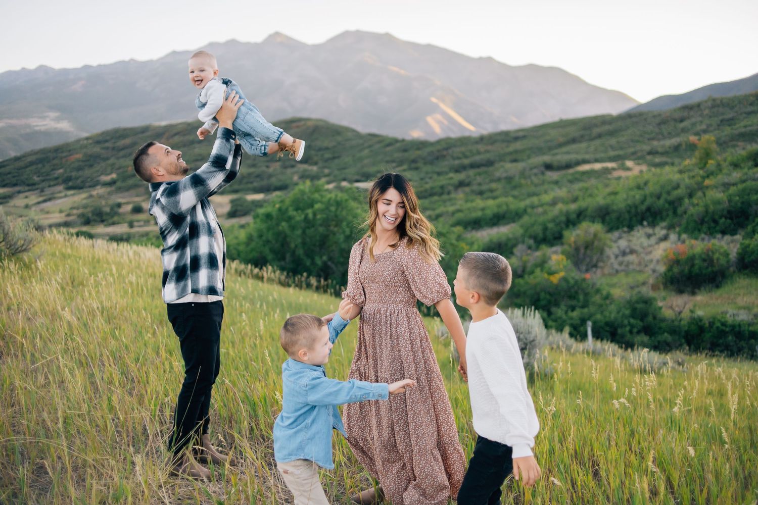 A family dancing in the Utah mountains at golden hour