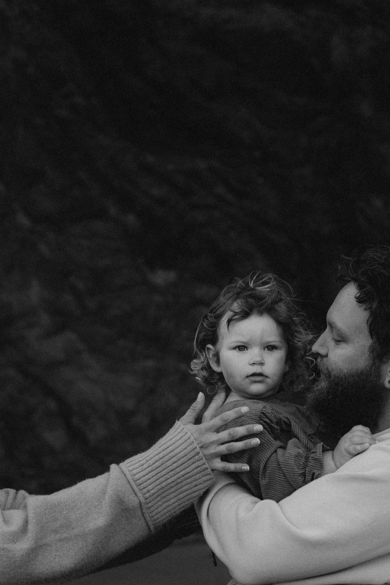 A black and white photo of a dad holding his little girl during an intimate family photoshoot