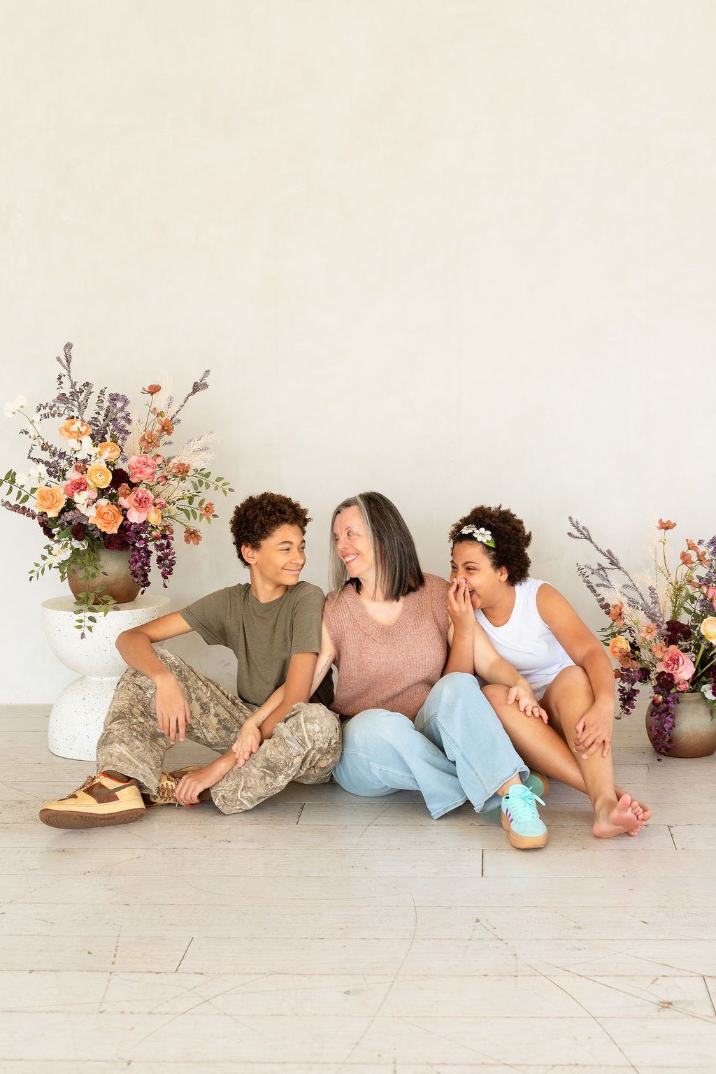 Mom with two adopted teenaged children laughing candidly during a photoshoot celebrating motherhood
