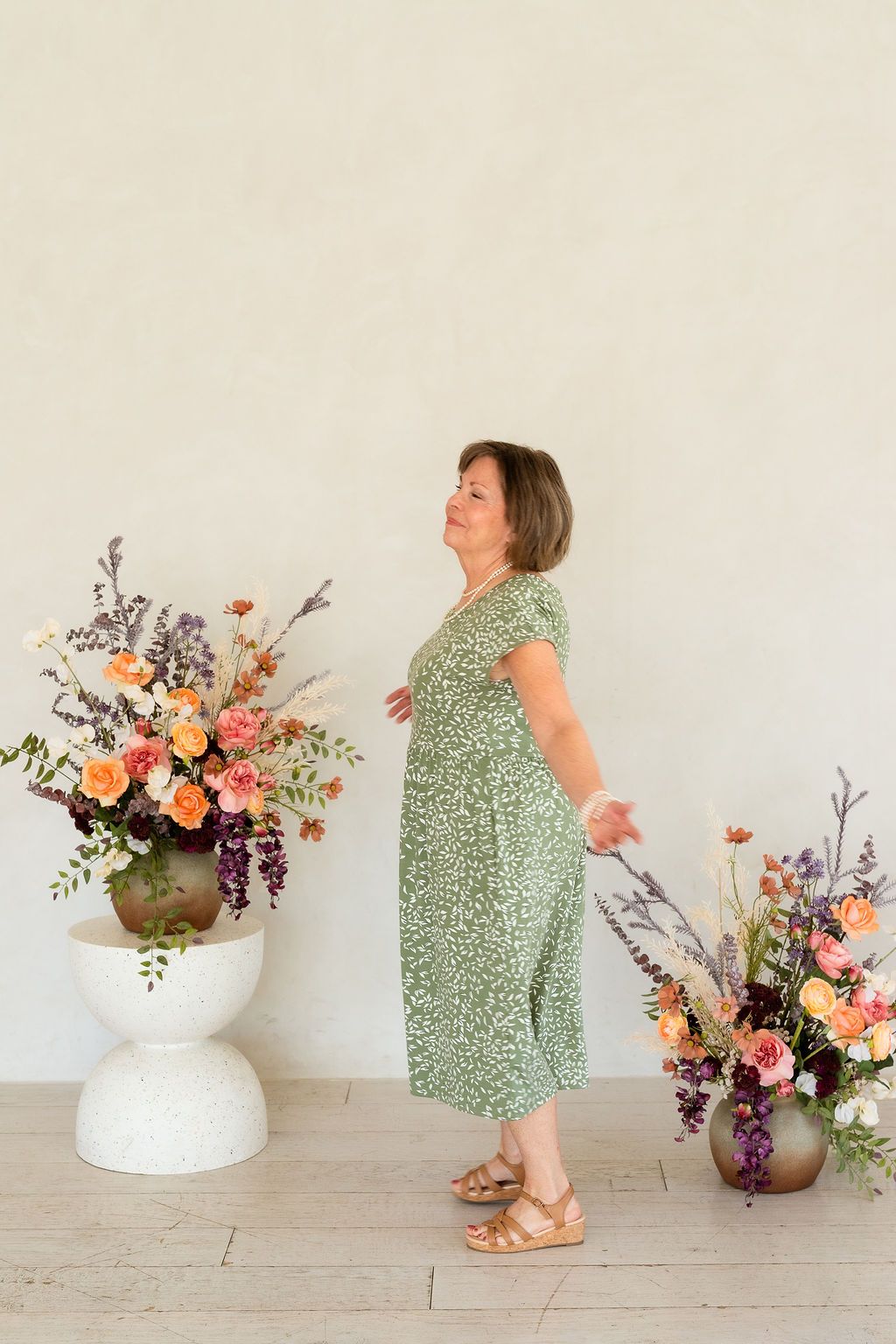 Mature woman dancing in a white studio celebrating her years of motherhood