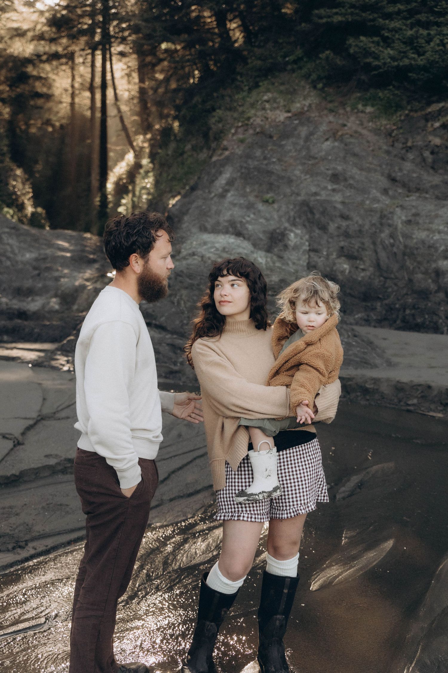 A family of three enjoy each other's company during a documentary family photoshoot at sunrise