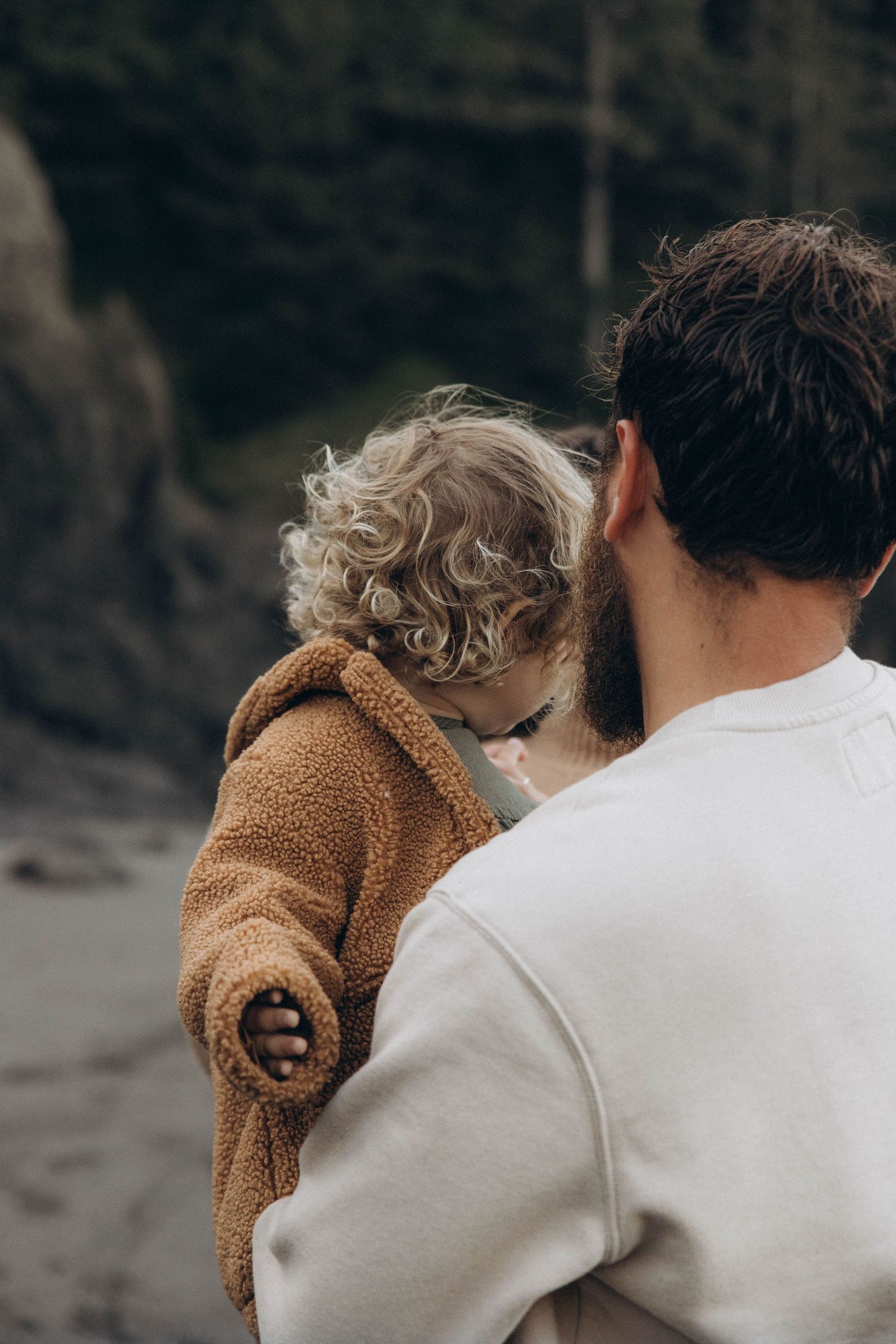 A dad explores the Oregon Coast beach with his daughter during sunrise