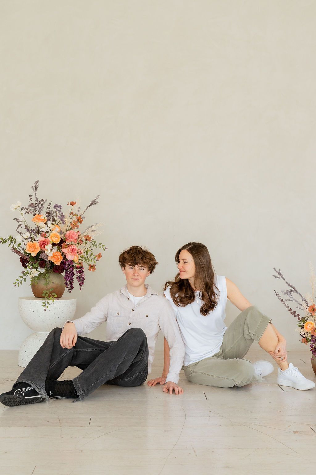 Mom fondly smiling at teenaged son during an indoor studio photoshoot celebrating women in different stages of motherhood