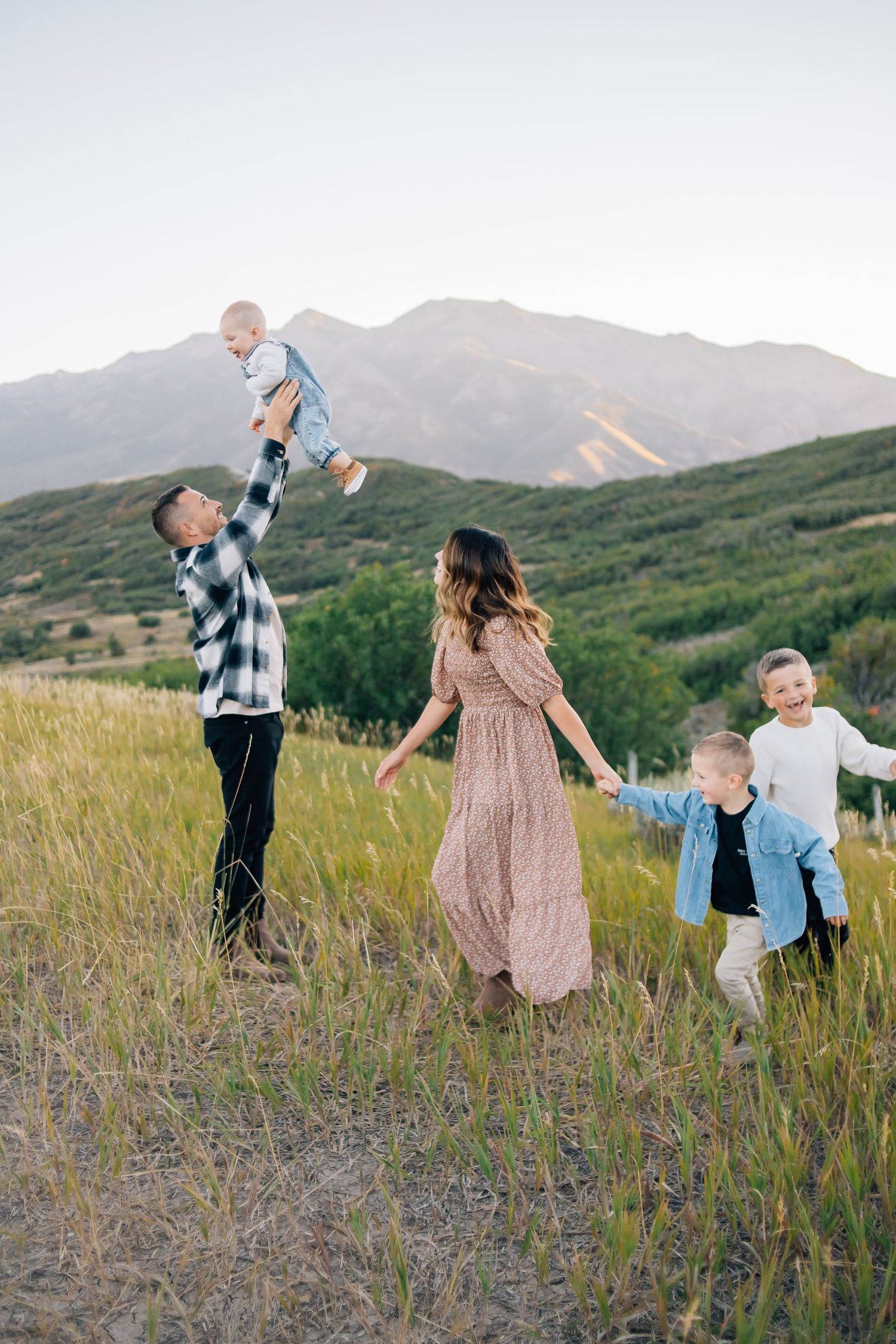 A family playing in the mountains during the natural light at golden hour