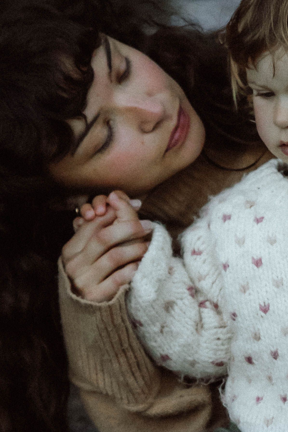 Details of a mother cuddling her baby during a documentary photoshoot outdoors