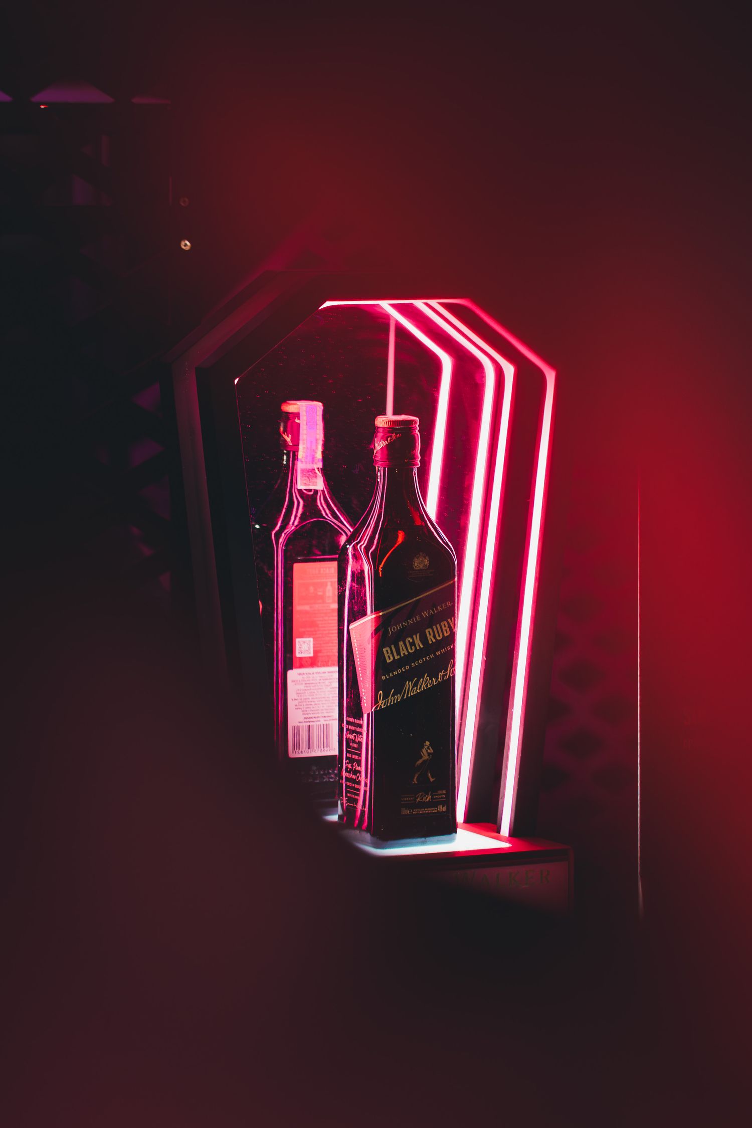 Fotografie comerciala de produs pentru sticla de Johnnie Walker pe un raft cu lumina neon