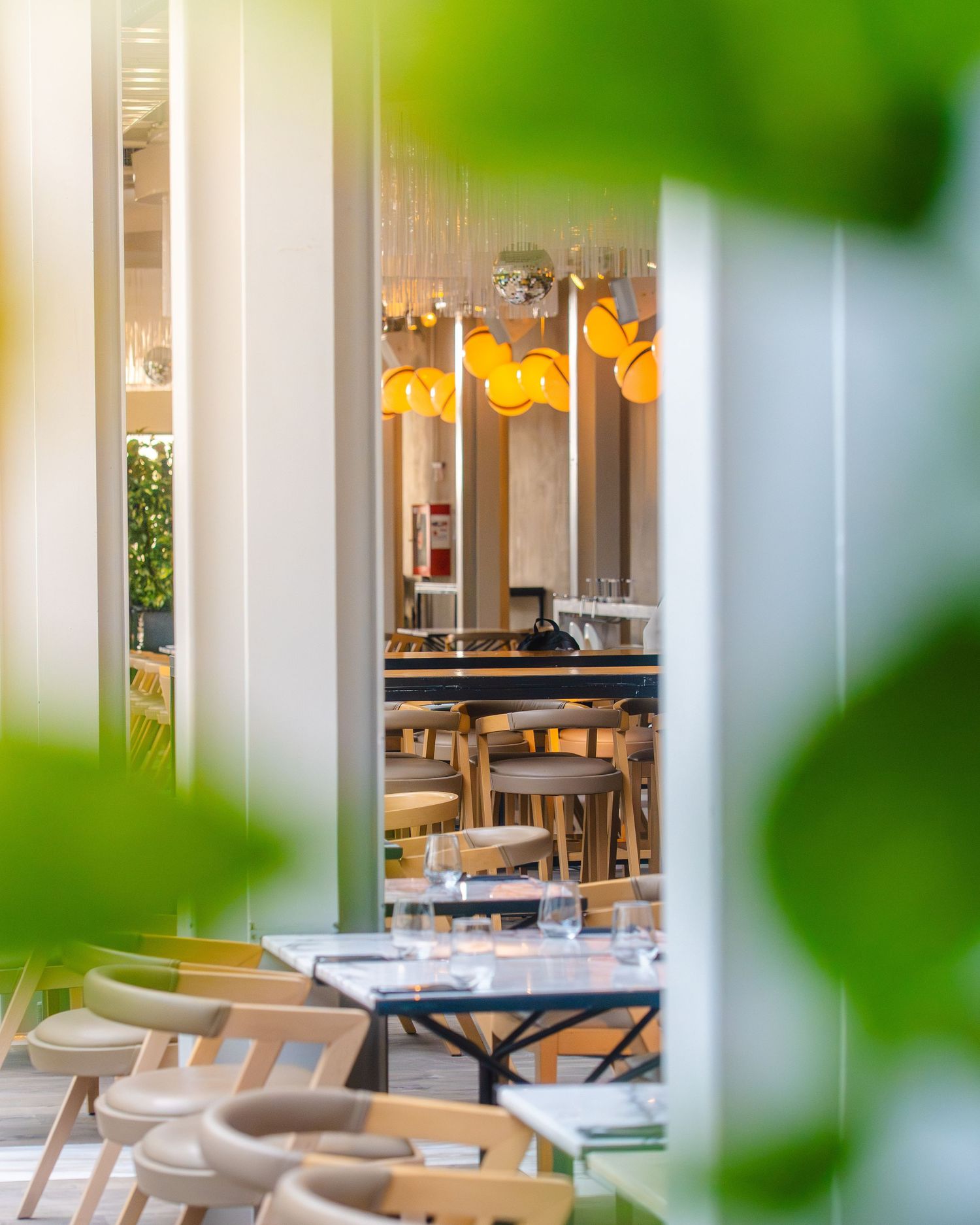 Interior luminos de restaurant modern vazut printre plante, fotografie comerciala de locatie