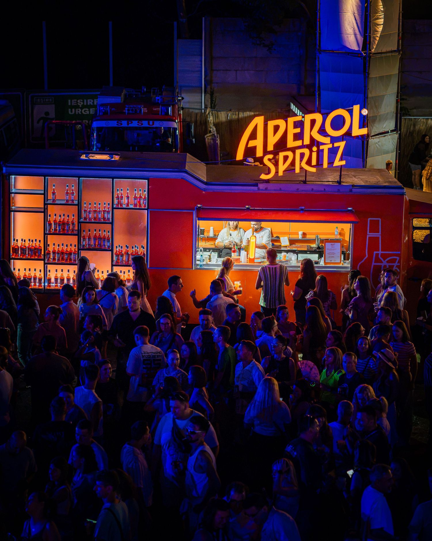 Multime adunata la barul in aer liber Aperol Spritz noaptea la festival