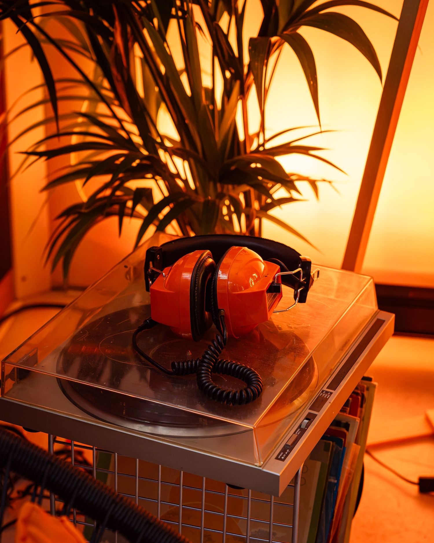 Telefon vintage portocaliu cu casti pe o plataneta sub lumina ambientala de eveniment