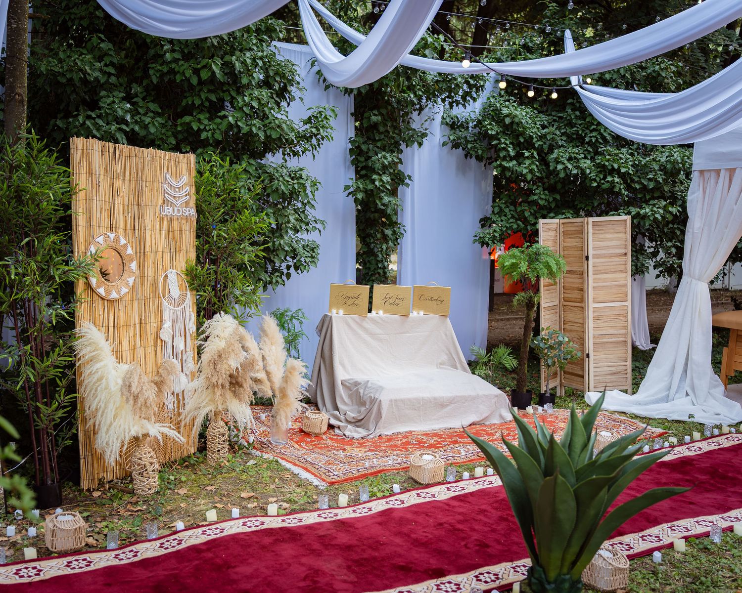 Zona de relaxare spa in aer liber cu draperii albe si decor natural la festival