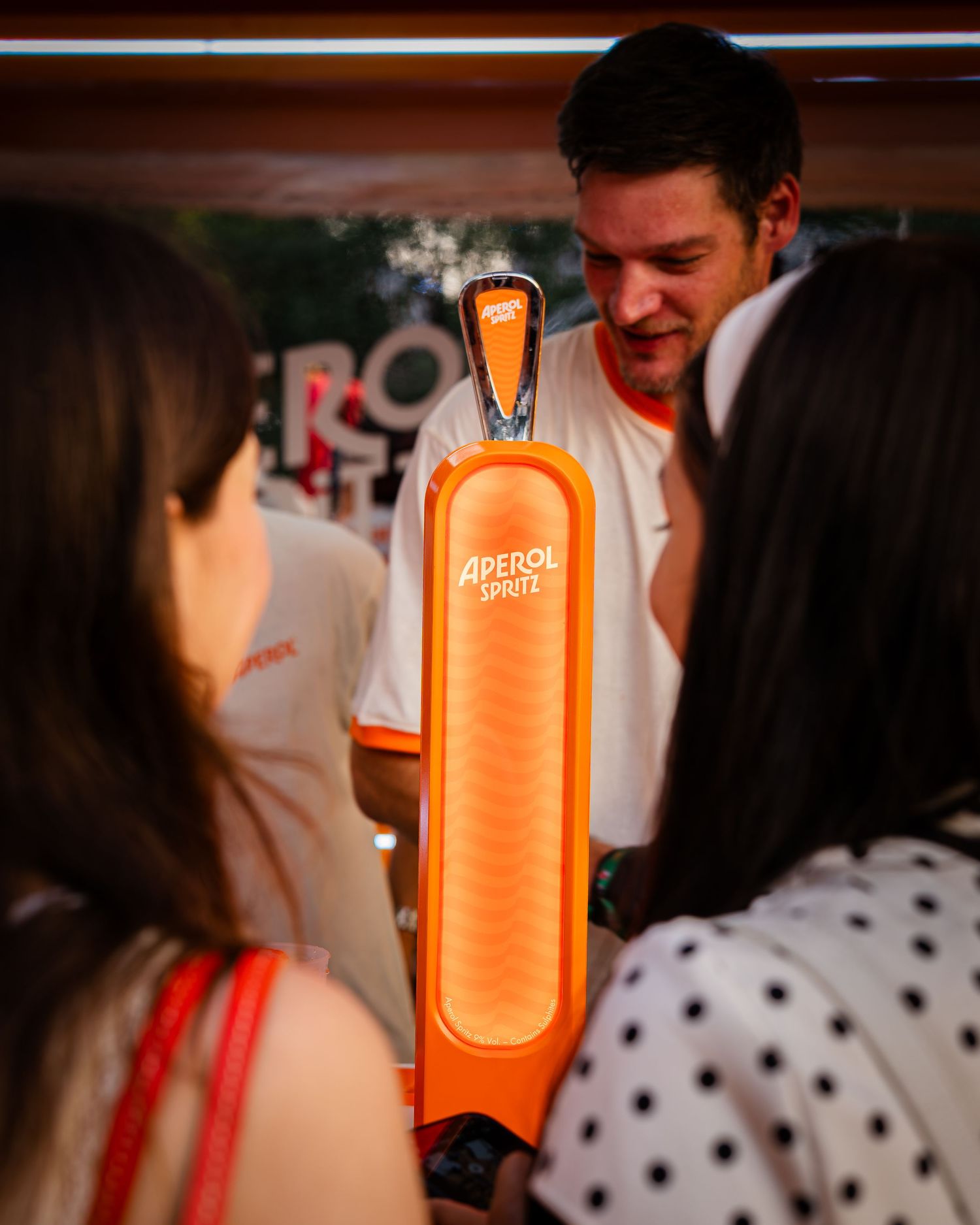Barman servind bauturi de la un stand Aperol Spritz la un eveniment in aer liber