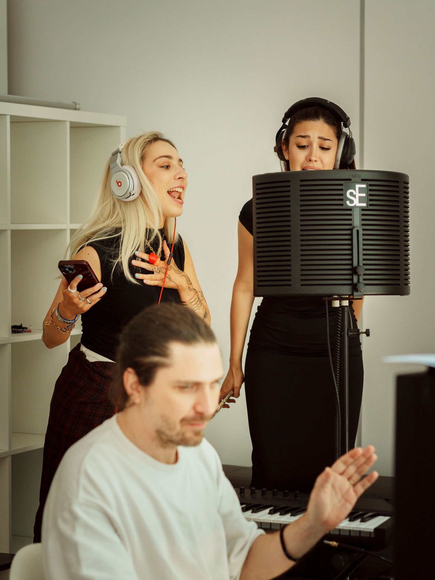 Doua soliste inregistrand cu casti la microfon intr-un studio muzical, fotografie fotojurnalistica