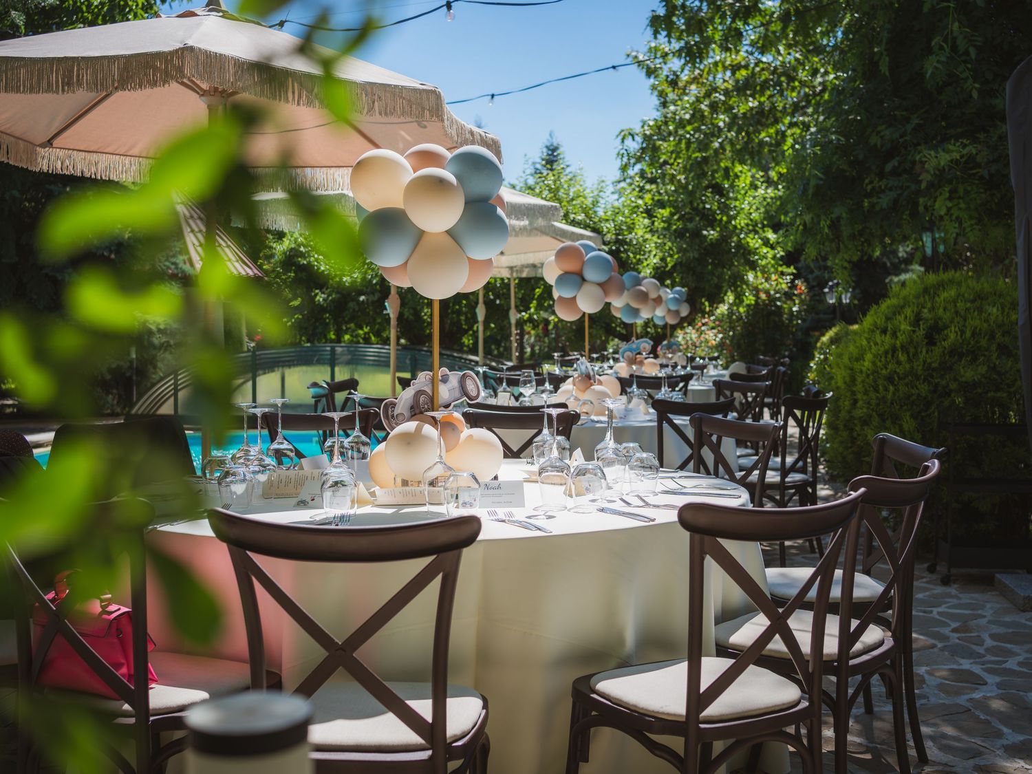 Aranjament elegant de masa pentru botez in aer liber cu decoratiuni din baloane
