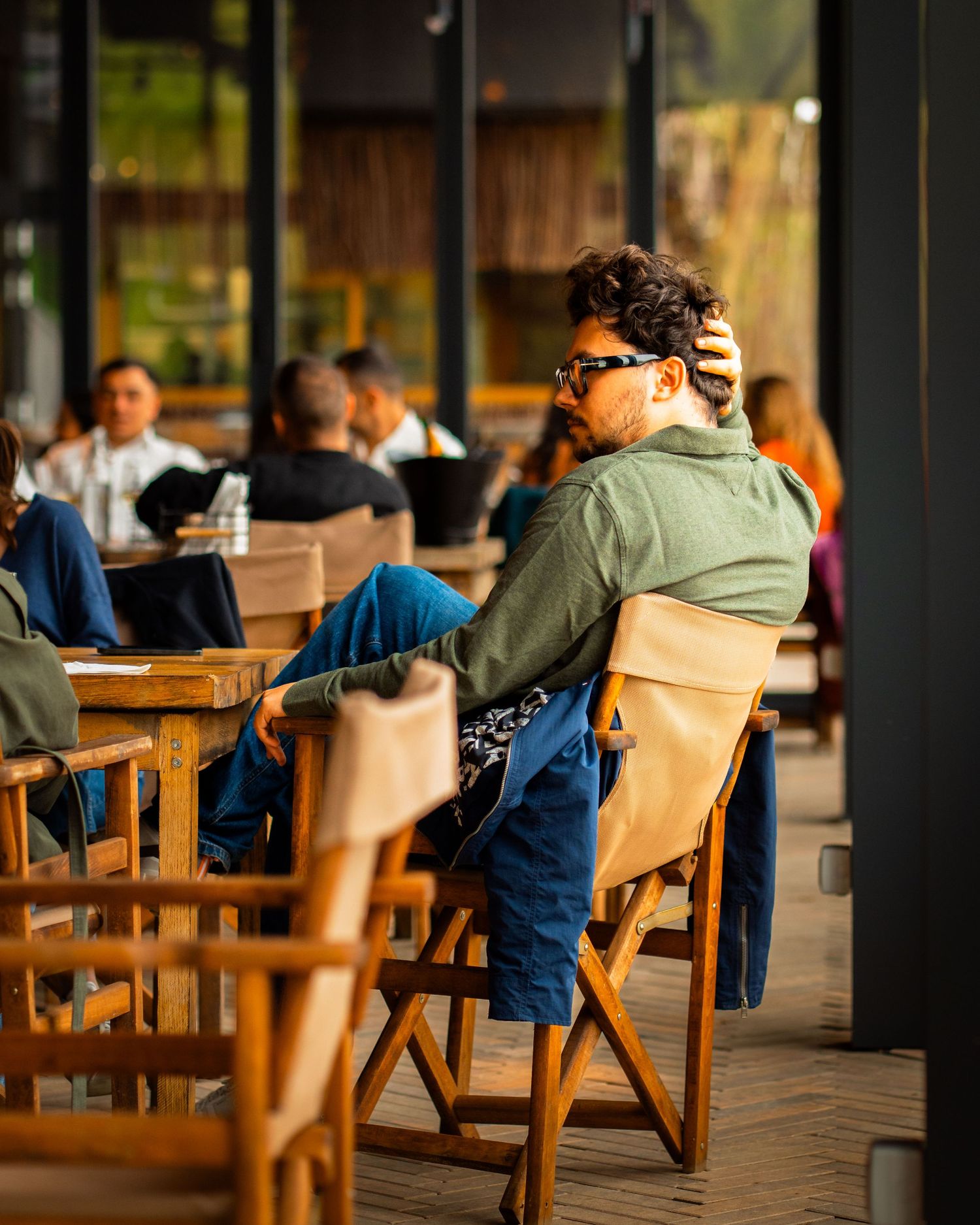 Barbat relaxandu-se la o masa pe terasa unei cafenele, fotografie comerciala de locatie